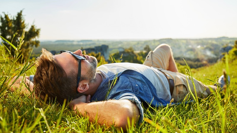 Mann liegt im Gras und geniesst das Leben - sei einzigartig Abnehmen Gesundheit